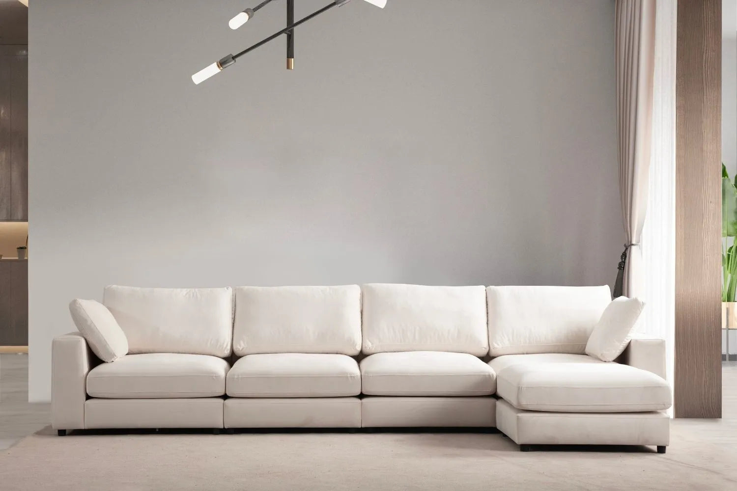 Canapé JULIA modulable en velours blanc cassé avec 4 places et un pouf, vue de face dans un salon moderne.