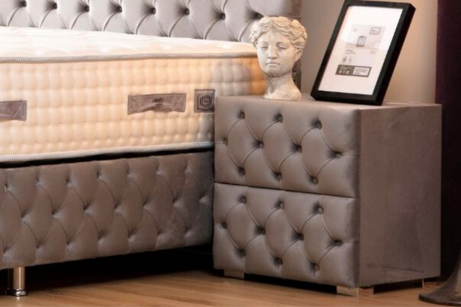 Chevet CAPITONNÉ en velours gris, avec un design chic et des détails capitonnés, parfait pour une chambre moderne et sophistiquée.