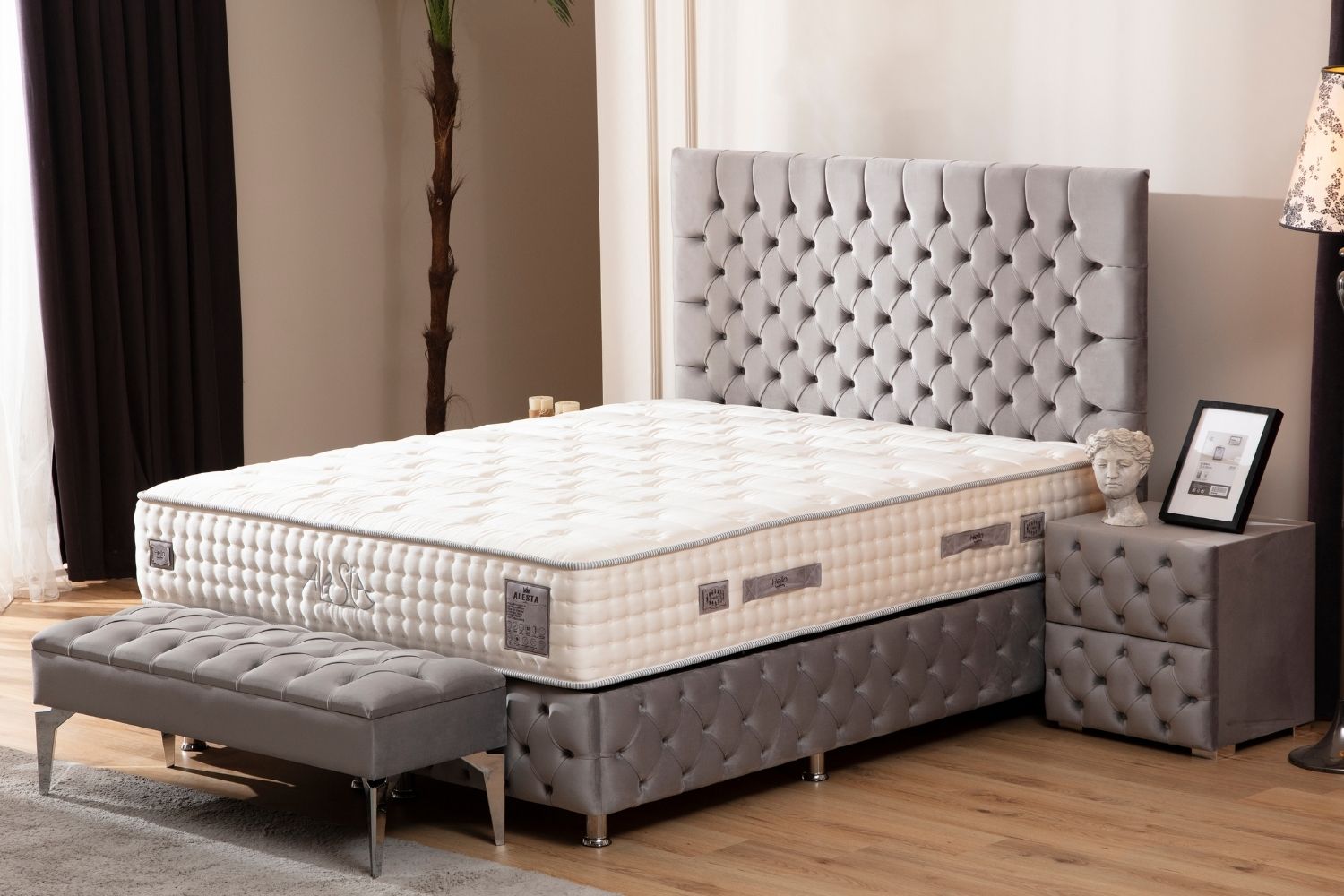 Lit coffre LAGOS en velours gris dans une chambre moderne, vue latérale avec décor, intégrant parfaitement le lit dans l’espace.