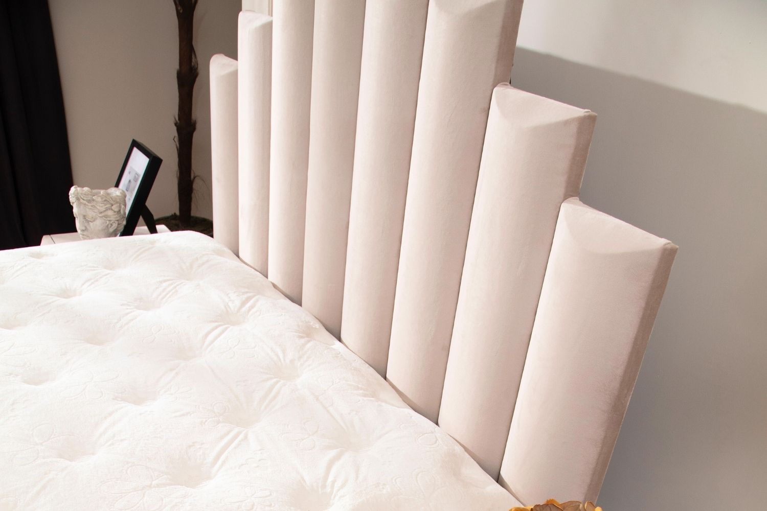 Zoom sur la tête de lit du lit coffre NATURA en velours beige, mettant en avant la texture luxueuse du velours et les détails du design.